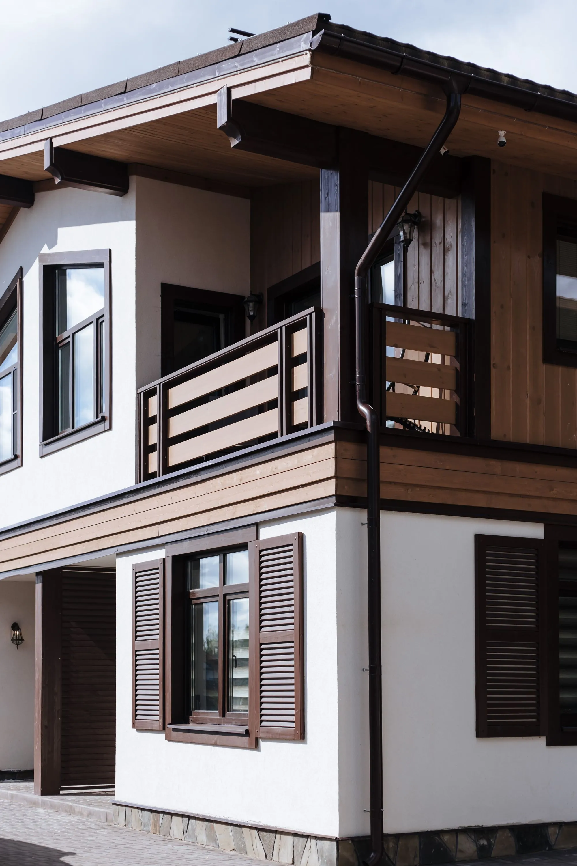 A modern house elevation with shuttered windows and a balcony