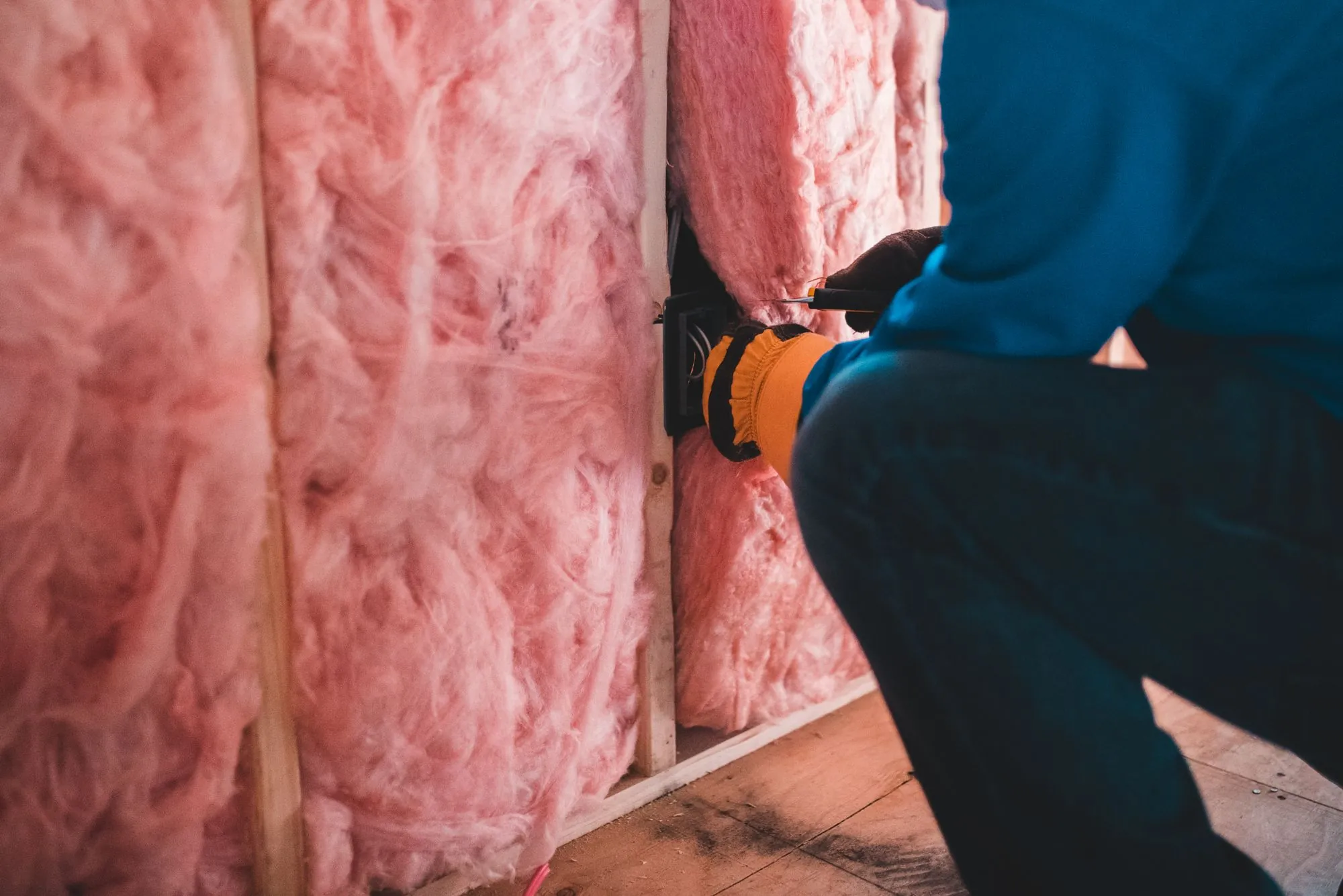 Fibreglass insulation being fitted between timber studs