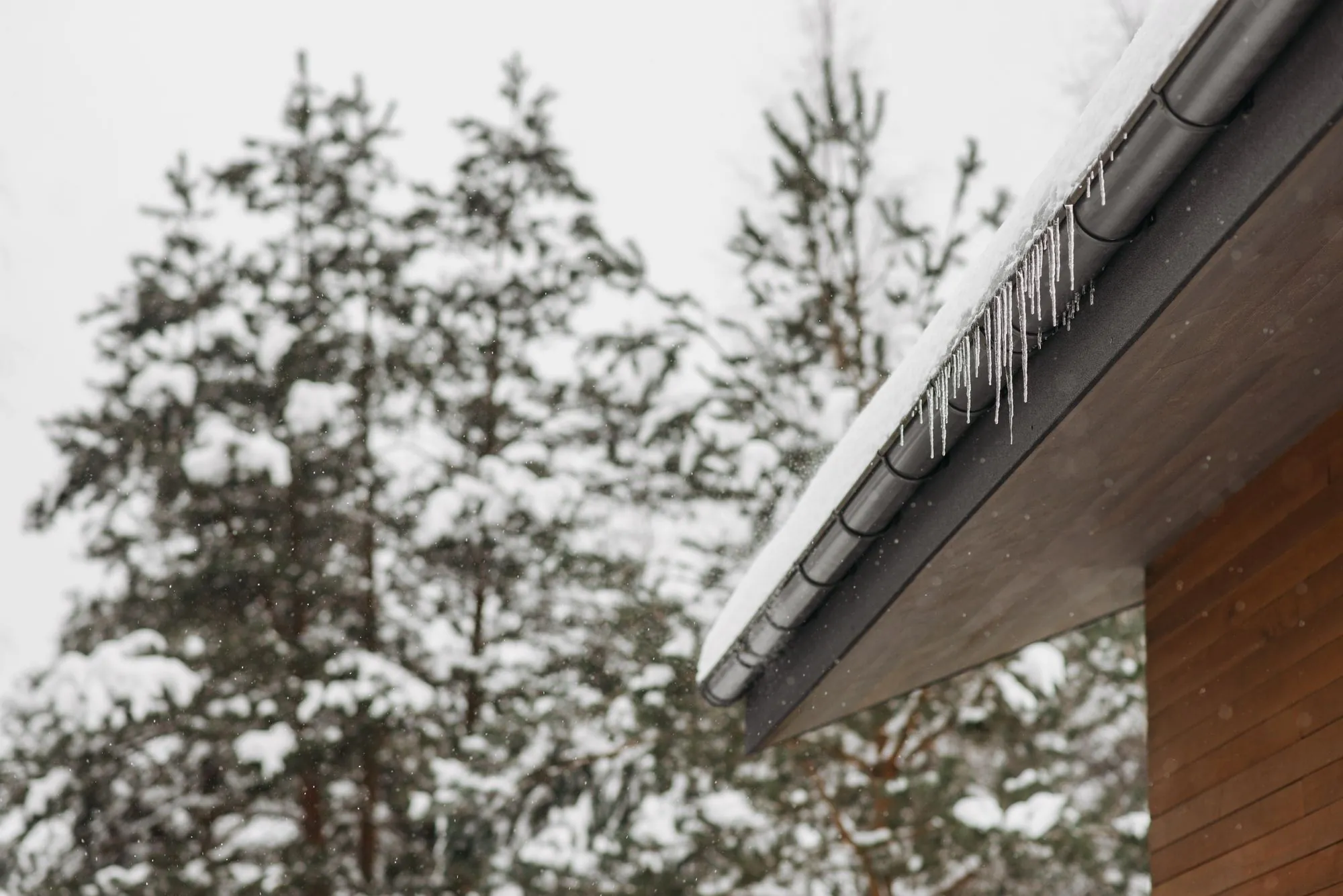 Icicles hanging in a row from the edge of a roof